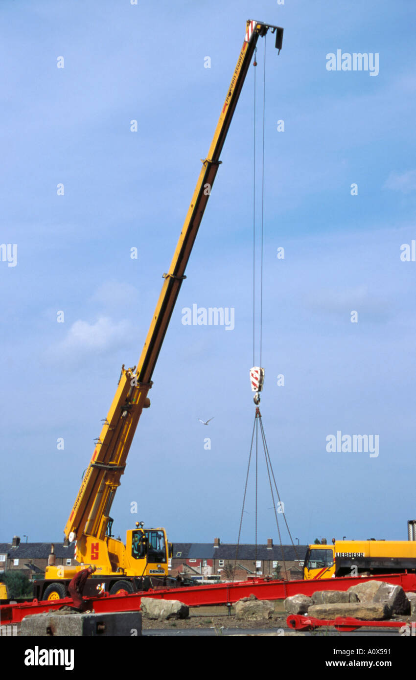 Mobile crane with telescopic boom extending at construction site — the type of crane requiring LMI load monitoring